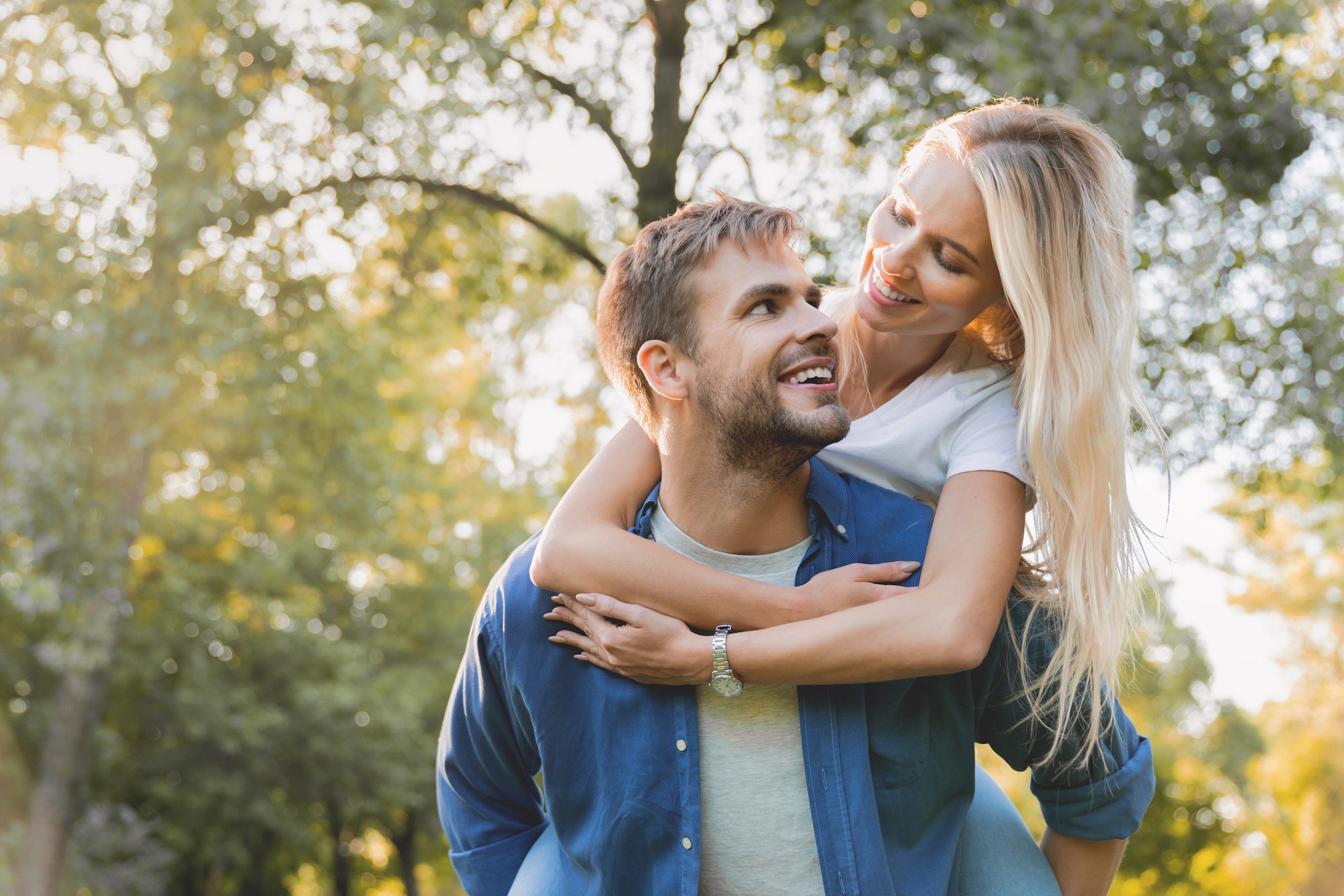 low-angle-view-of-young-beautiful-couple-piggybacking-and-having-fun-outdoors-.jpg